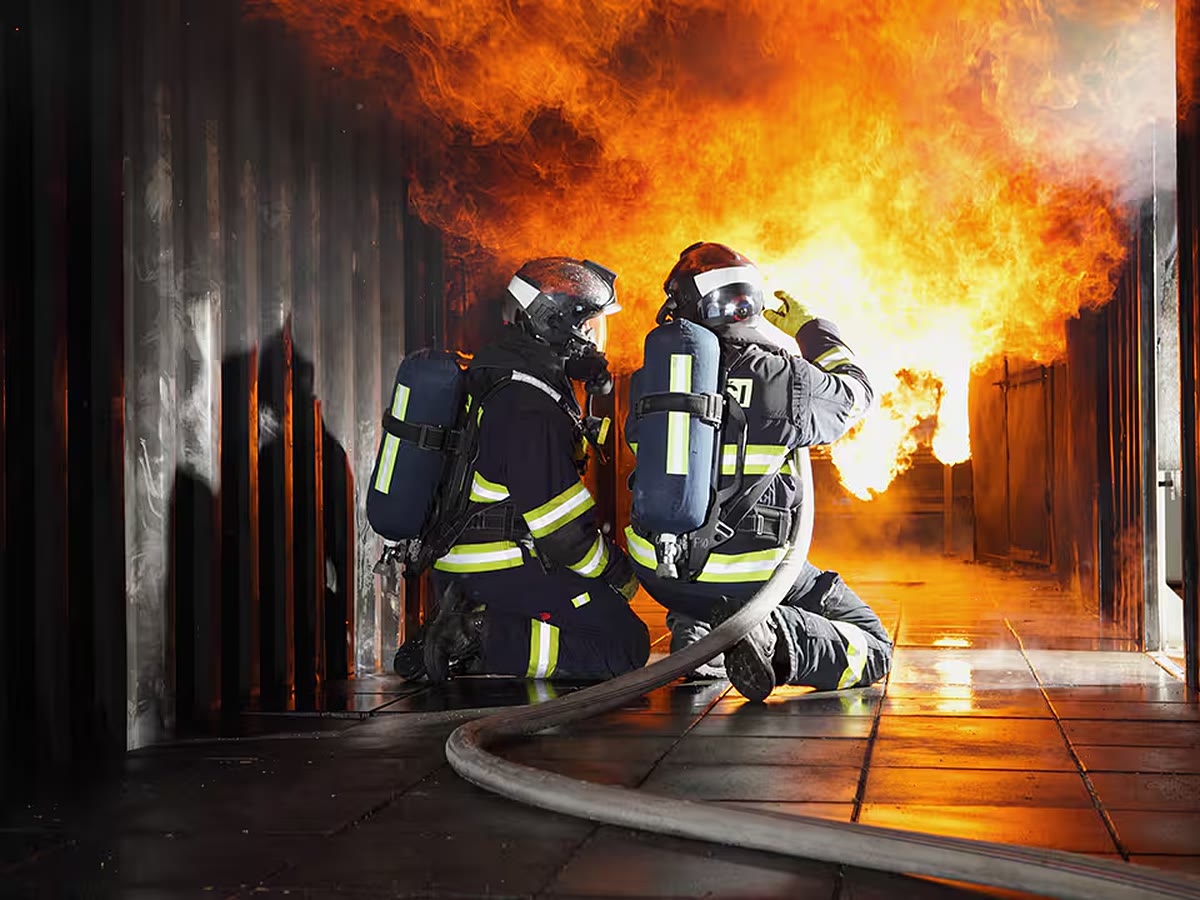 Firefighters wearing breathing apparatus during an indoor fire response.
